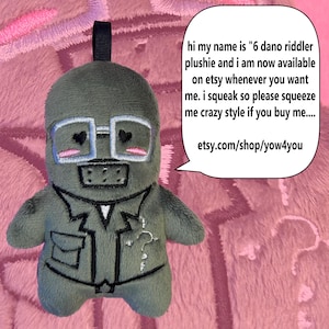 Könnte beinhalten: Ein grünes Riddler-Plüschtier mit weiß gerahmter Brille und einem Fragezeichen auf der Jacke. Die Sprechblase enthält den Text "hi my name is '6 dano riddler plushie...etsy.com/shop/yow4you". Das Spielzeug hat eine schwarze Schlaufe oben.