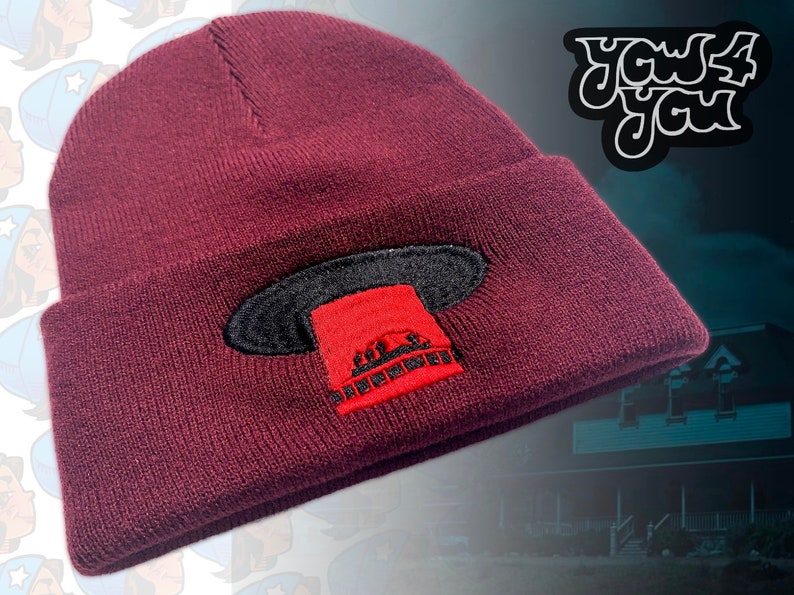 Peut inclure: Un bonnet marron avec un motif brod&eacute; noir et rouge d'un OVNI. Le motif repr&eacute;sente une soucoupe volante rouge avec des d&eacute;tails noirs et le texte "You4You".
