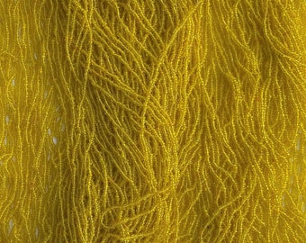 Puede incluir: Un paquete de cuentas de semillas de color amarillo brillante, perfecto para hacer joyas o proyectos de manualidades.