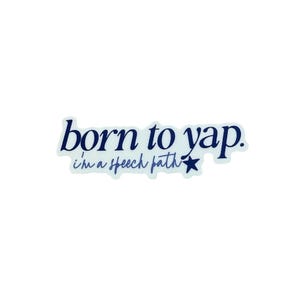 Puede incluir: Una pegatina blanca con el texto "born to yap." en escritura azul oscuro. Debajo, el texto "i'm a speech path" está escrito en una fuente más pequeña, azul claro, con una estrella azul al final.