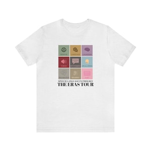 May include: White t-shirt with a graphic design of a grid of nine squares. Each square contains a different icon representing a different aspect of speech-language pathology. The text "SPEECH LANGUAGE PATHOLOGY THE ERAS TOUR" is printed below the grid.