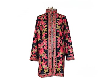 May include: A long, black coat with a high collar and long sleeves. The coat is adorned with intricate embroidery featuring red and green floral patterns. The embroidery is concentrated along the front, collar, and cuffs, creating a striking visual contrast.