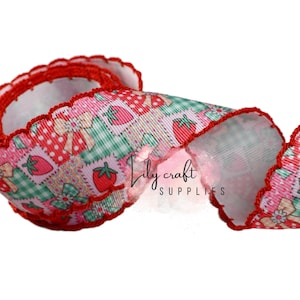 May include: A decorative ribbon with a repeating pattern of strawberries, bows, and patchwork squares in pink, green, and red. The ribbon has a scalloped red edge and is ideal for crafting and gift wrapping.