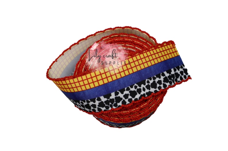K&ouml;nnte beinhalten: Eine Rolle dekoratives Band mit einem Design, das von einem Outfit einer Figur inspiriert wurde. Das Band hat ein rotes, gelbes, blaues und schwarzes Muster. Das Band wird wahrscheinlich f&uuml;r Bastelarbeiten, Geschenkverpackungen oder andere dekorative Zwecke verwendet.