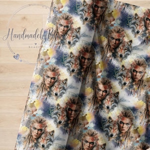 Könnte beinhalten: Ein Stoffdruck mit einem sich wiederholenden Muster aus menschlichen Gesichtern mit langem Haar, die mit Wolfsköpfen verflochten sind, akzentuiert durch aquarellartige Spritzer in Gelb, Blau und Violett, mit dem Text "Handmadeby Stoffe" oben links.