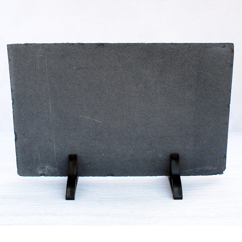 May include: A black slate plaque with a textured surface and two black metal kickstands. The plaque is blank and ready for personalization.