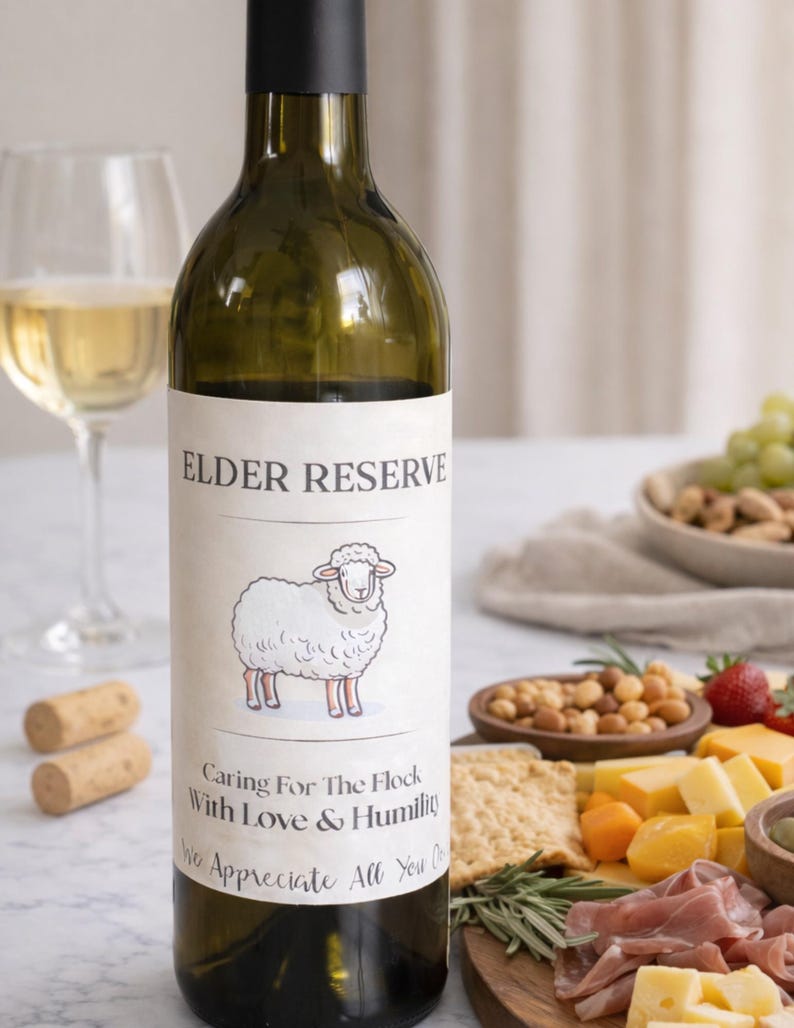 May include: A green wine bottle with a black cap and a label that reads "ELDER RESERVE." The label features a cartoon sheep and the text "Caring For The Flock With Love & Humility." A wine glass, corks, and a charcuterie board with snacks are in the background.