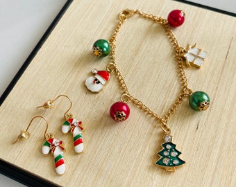 Julsmyckeset: berlockarmband i guld med jultomtegåva och julgranshänge, och polkagrisörhängen i rött och vitt.