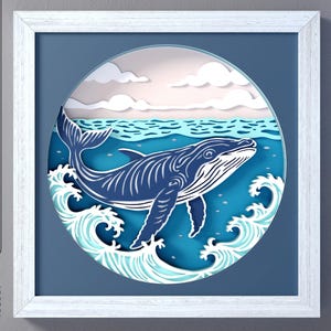 May include: A layered paper art piece featuring a blue whale swimming in the ocean, framed in a white square. The artwork includes waves, clouds, and the text "CutCute paper". The image also shows file type options: SVG, DXF, EPS, and PDF.