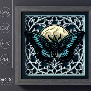 May include: A framed paper art piece featuring a black and teal butterfly against a full moon and ornate, white filigree. The artwork is layered, creating a 3D effect. The frame is gray, and the image includes the text "SVG", "DXF", "EPS", "PDF", and "CutCute Paper".