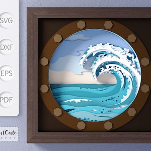 May include: A papercraft wave design in a brown wooden frame. The wave is blue and white with a light blue sky and white clouds in the background.