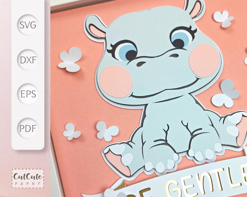 May include: A light blue hippopotamus with pink cheeks and eyelashes. The hippopotamus is sitting on a peach background with white butterflies. The hippopotamus is holding a white banner with the words 'Be Gentle' in gold letters.