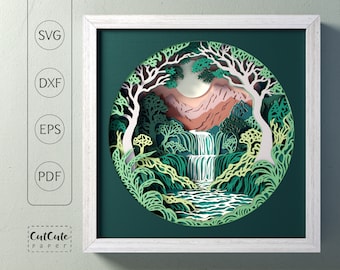 May include: A paper cut-out art piece depicting a waterfall cascading through a lush green forest. The scene is framed in a white frame with a green background.