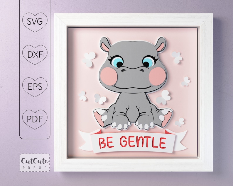 May include: A white frame with a pink background and a gray hippopotamus sitting in the center. The hippopotamus has blue eyes and pink cheeks. The hippopotamus is surrounded by white butterflies. The text 'BE GENTLE' is written on a red banner below the hippopotamus.