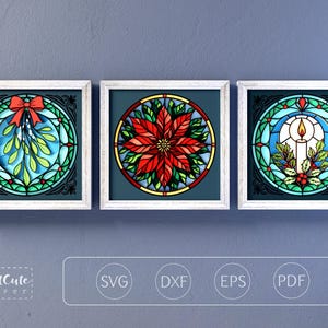 Könnte beinhalten: Drei gerahmte Glasmalereien mit weißen Rahmen. Die Kunstwerke zeigen weihnachtliche Motive: Mistelzweige mit roter Schleife, einen Weihnachtsstern und eine Kerze mit Stechpalme. Der Hintergrund ist dunkelblaugrün.
