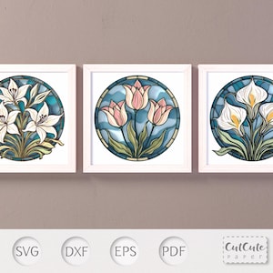 Peut inclure: Trois impressions d'art floral encadrées. Chaque impression présente un motif circulaire de vitrail avec des lys blancs, des tulipes roses et des arums blancs, respectivement, sur un fond bleu et turquoise. Les cadres sont blancs, et le style général est décoratif.