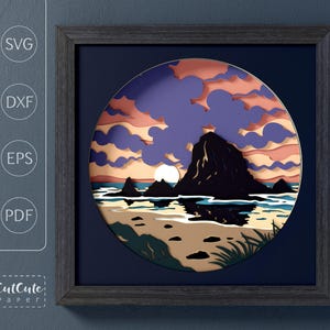 Peut inclure: Une œuvre d'art en papier encadrée représentant un coucher de soleil sur une plage avec une grande formation rocheuse. L'œuvre utilise des couches de papier dans des tons de bleu, d'orange et de jaune, créant un effet 3D. Le cadre est gris foncé et l'œuvre est étiquetée avec "SVG", "DXF", "EPS" et "PDF".