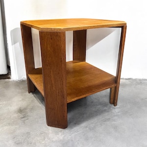 May include: A small, square, wooden end table with a shelf. The table is made of dark wood and has a simple, modern design.