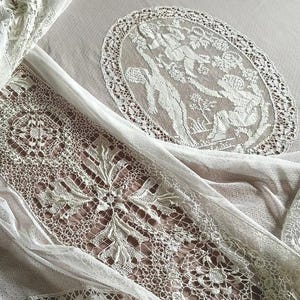A vintage French tulle bedspread with superb hand woven lace and fine embroidered filet lace medallions decorated with cherubs, circa 1930s.