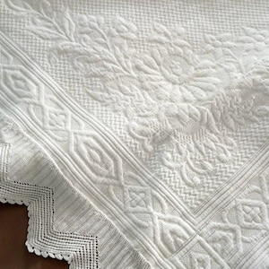 Uma colcha vintage francesa Marcella em piqué de algodão branco com franjas e borda de renda tricotada.