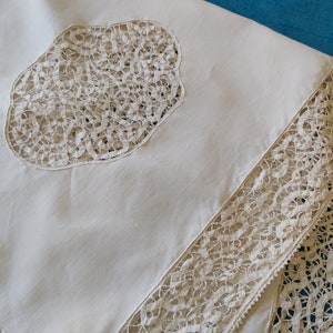 A vintage French pure linen tablecloth, handmade in the mid 20th century, with tape lace embroidered inset panels and edging.