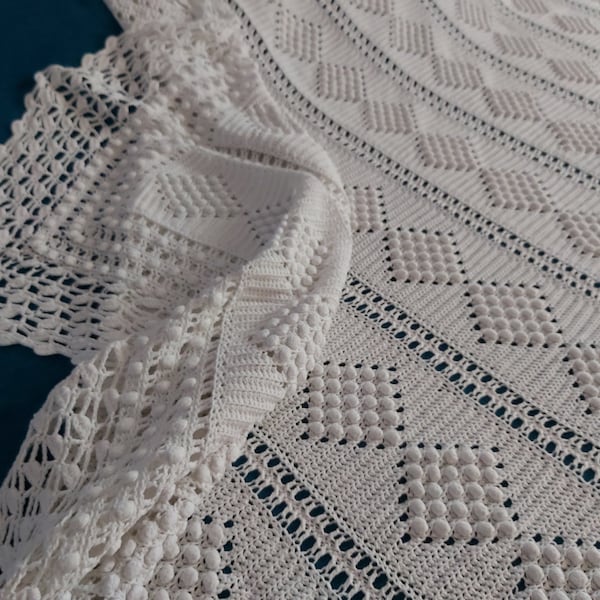 Un grand couvre-lit ou un canapé en coton à motifs de pop-corn blanc vintage au crochet à la main avec une bordure en dentelle au crochet profonde
