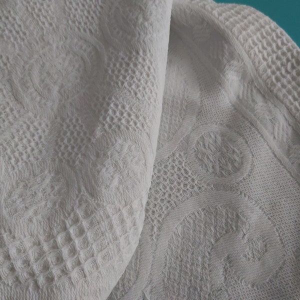 A soft white vintage French waffle weave cotton throw - a small bedspread for a childs bed, or for a sofa or chair.