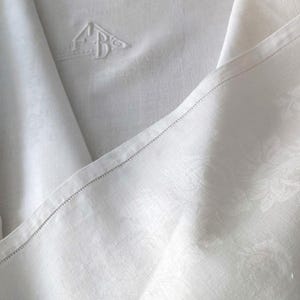 En magnífico damasco fino de lino puro, un mantel blanco francés vintage con monograma FB bordado central que data de la década de 1930.