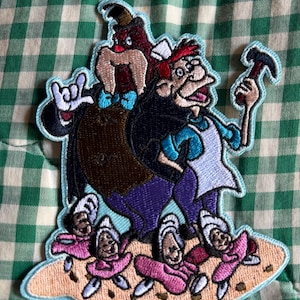 May include: Embroidered patch featuring characters from Alice in Wonderland. The patch includes the Walrus, the Carpenter, and the oysters. The characters are outlined in a light blue stitch, with a tan base and a green and white checkered background.