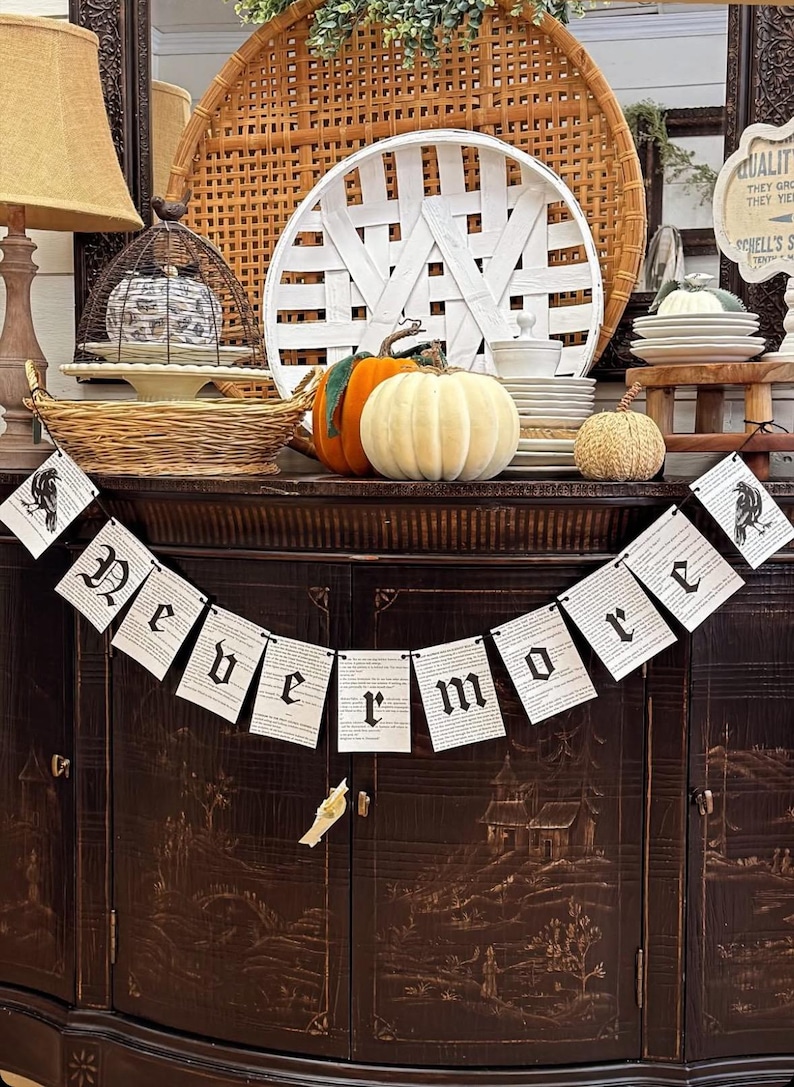 May include: A decorative Halloween display featuring a banner that reads "Nevermore" with raven illustrations. The display includes pumpkins, decorative plates, and a woven basket. The color palette is autumnal, with warm tones and a vintage aesthetic.