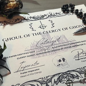 May include: A certificate with ornate borders and gothic-style text, reading "Ghoul of the Clergy of Ghost." It features signatures, a skull illustration, and the word "Catalyst." A pen, rosary beads, and a pendant with a skull are also present.
