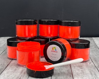 May include: Eight small jars of bright orange neon pigment powder. The label on one jar reads "Aroma Craft Supplies Neon Hunter's Orange".