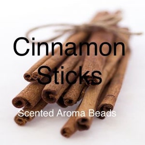 May include: A bundle of cinnamon sticks tied with twine, against a white background. The text "Cinnamon Sticks" is above the sticks, and "Scented Aroma Beads" is below.