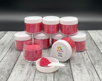 May include: Eight small jars of hot pink mica powder, with one jar open and a scoop of powder in a white lid. The jar with the open lid has a label that reads "Aroma Bead Supply Hot Pink".