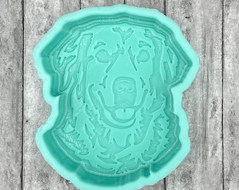 May include: A light teal silicone mold in the shape of a dog's head. The mold features detailed facial features, including eyes, nose, and mouth. The mold is designed for crafting and creating dog-themed items.