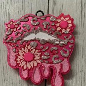 May include: Pink glitter lips with a leopard print design and white flowers. The lips are dripping with pink glitter.