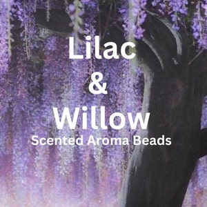 May include: Image features the text "Lilac & Willow Scented Aroma Beads" in white font. The background is a soft focus image of a tree with cascading purple flowers, creating a serene and natural aesthetic.