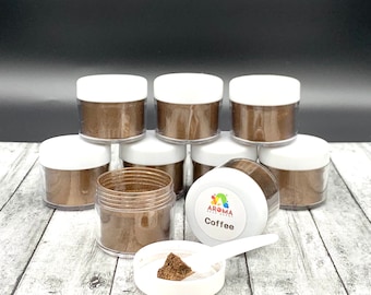 Może przedstawiać: Osiem małych słoiczków z brązowym pyłem mieniącym się, oznaczonych etykietą "Aroma Real Colors Coffee". Mała biała łopatka z próbką pyłu znajduje się na pierwszym planie.