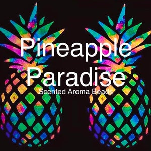 May include: Two colorful pineapple designs with the text "Pineapple Paradise" and "Scented Aroma Beads". The pineapples are decorated with a rainbow of colors, including green, blue, yellow, and pink, against a black background.