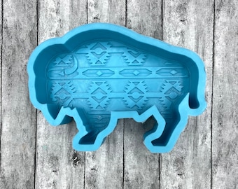 May include: A light blue silicone mold shaped like a buffalo with a geometric pattern. The mold is designed for making crafts or baking.