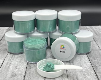 May include: Eight small jars of green mica powder, with one jar labeled "Pine" and a small scoop of powder in a separate jar.