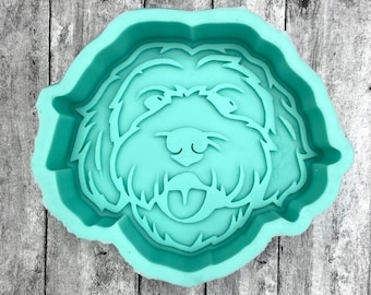 May include: A teal blue silicone mold shaped like a dog's head. The mold is designed to create a dog-shaped treat or cake.