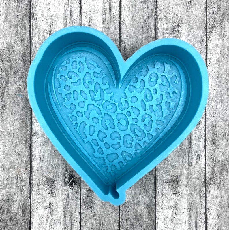 May include: A light blue silicone heart-shaped mold with a leopard print design.