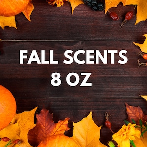 May include: Fall Scents 8 oz candle with a wooden background and autumn leaves, pumpkins, and berries.