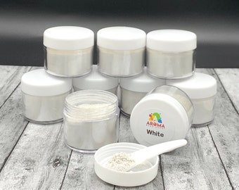 May include: Eight small white jars of white mica powder, with one jar in the center of the image with a white scoop and a label that reads "Aroma Food Colors White".