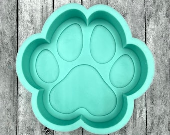 May include: A light green silicone mould shaped like a paw print. The mould has five toes and a heart-shaped pad.