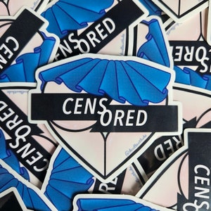 May include: A stack of stickers with a blue and white design. The stickers feature a heart shape with a black bar across the middle that says "CENSORED". The text "@dudtreats.bb" is printed on the bottom of the sticker.