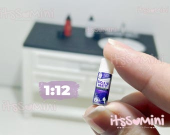 May include: Miniature Aqua Net hairspray bottle with a white cap and a purple and blue label. The label features the text "Aqua Net" and a graphic. The scale is 1:12.