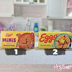 May include: Two miniature Eggo waffle boxes. One box is labeled "Eggo Minis Waffles Cinnamon Toast" and the other is labeled "Eggo Buttermilk". Each box has a picture of waffles and the number of waffles in the box.
