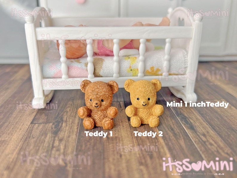 May include: Two miniature teddy bears, one light brown and one golden yellow, sit in front of a white doll-sized crib. The bears are labeled "Teddy 1" and "Teddy 2". The text "Mini 1 inch Teddy" is also visible.